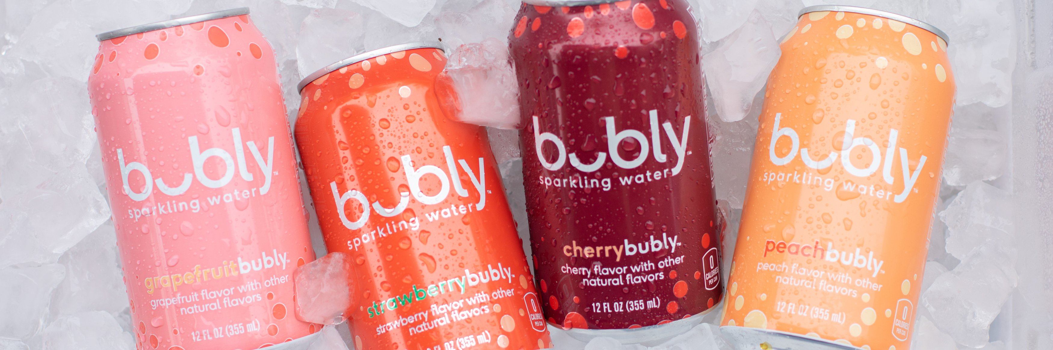 Four cans of bubly laying in a bed of ice